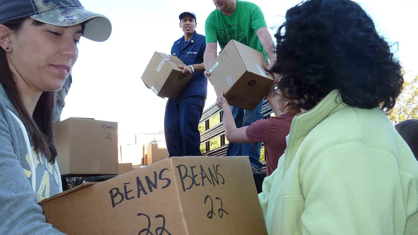 Volunteers helping neighbours collect groceries at a community distribution
