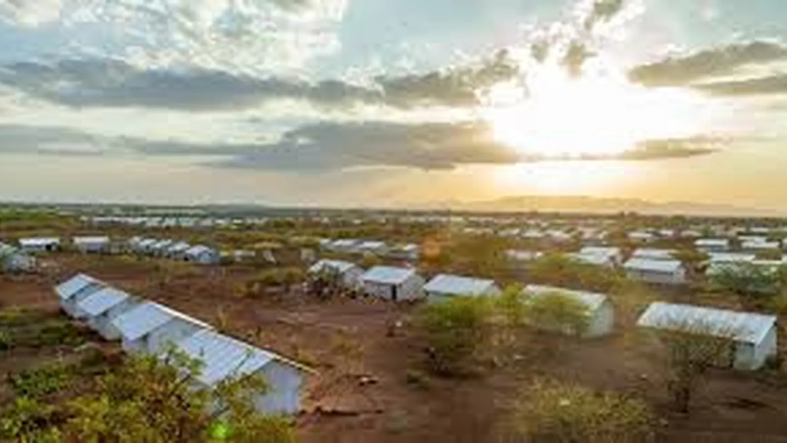 Aid convoy and shelter tents in an arid displacement site in Sudan
