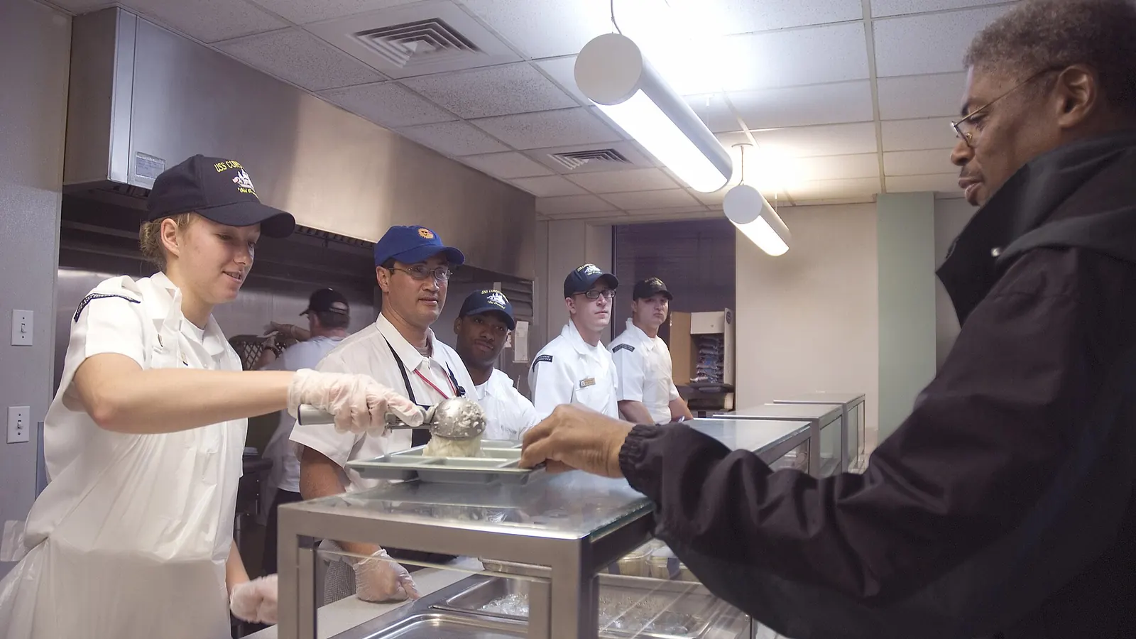 Volunteers serving hot meals to veterans at a community dining hall