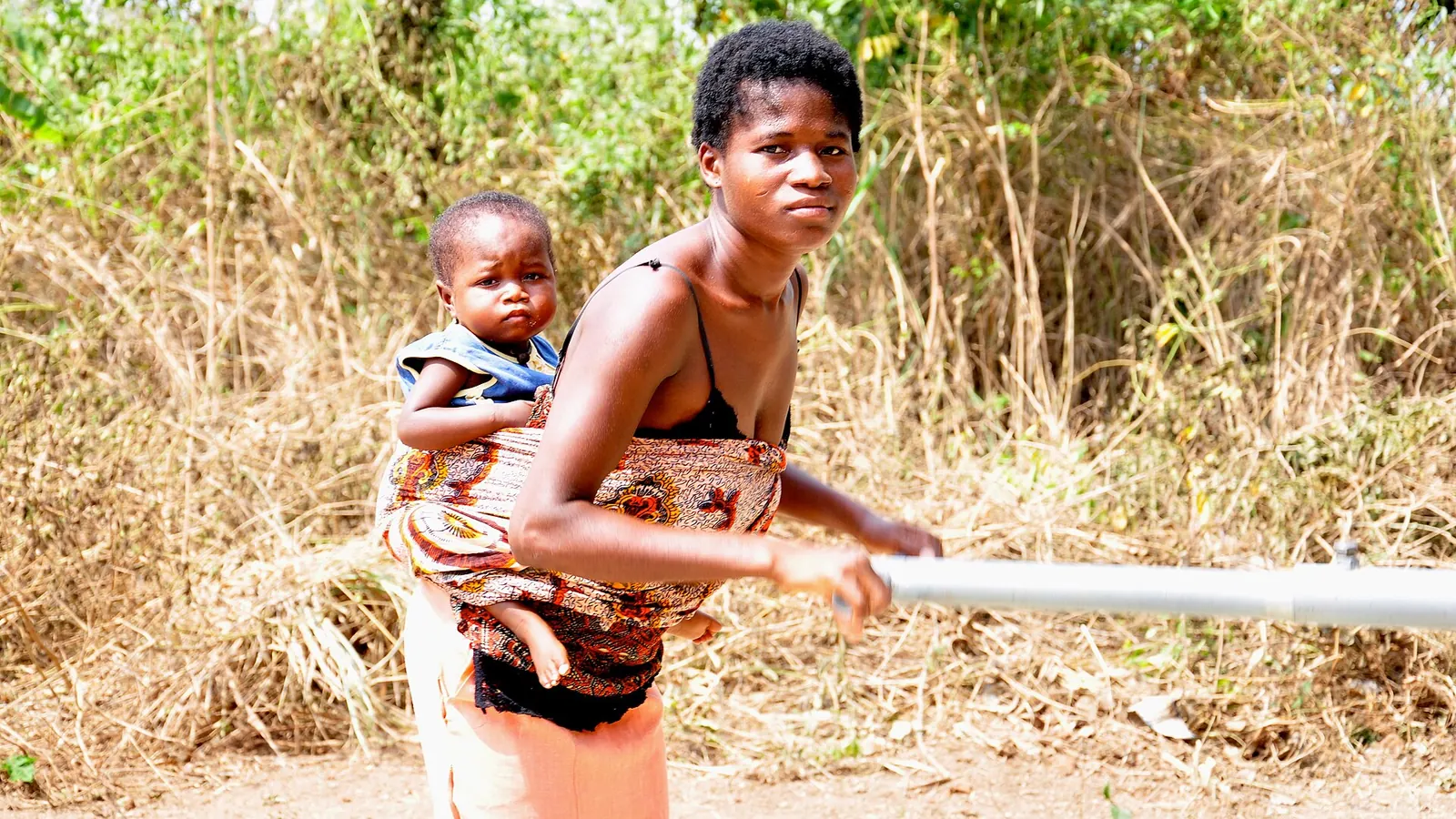 Photo: <a rel=nofollow class=external text href=https://www.flickr.com/people/5742 · Public domain A mother and child collecting clean water at a village hand pump