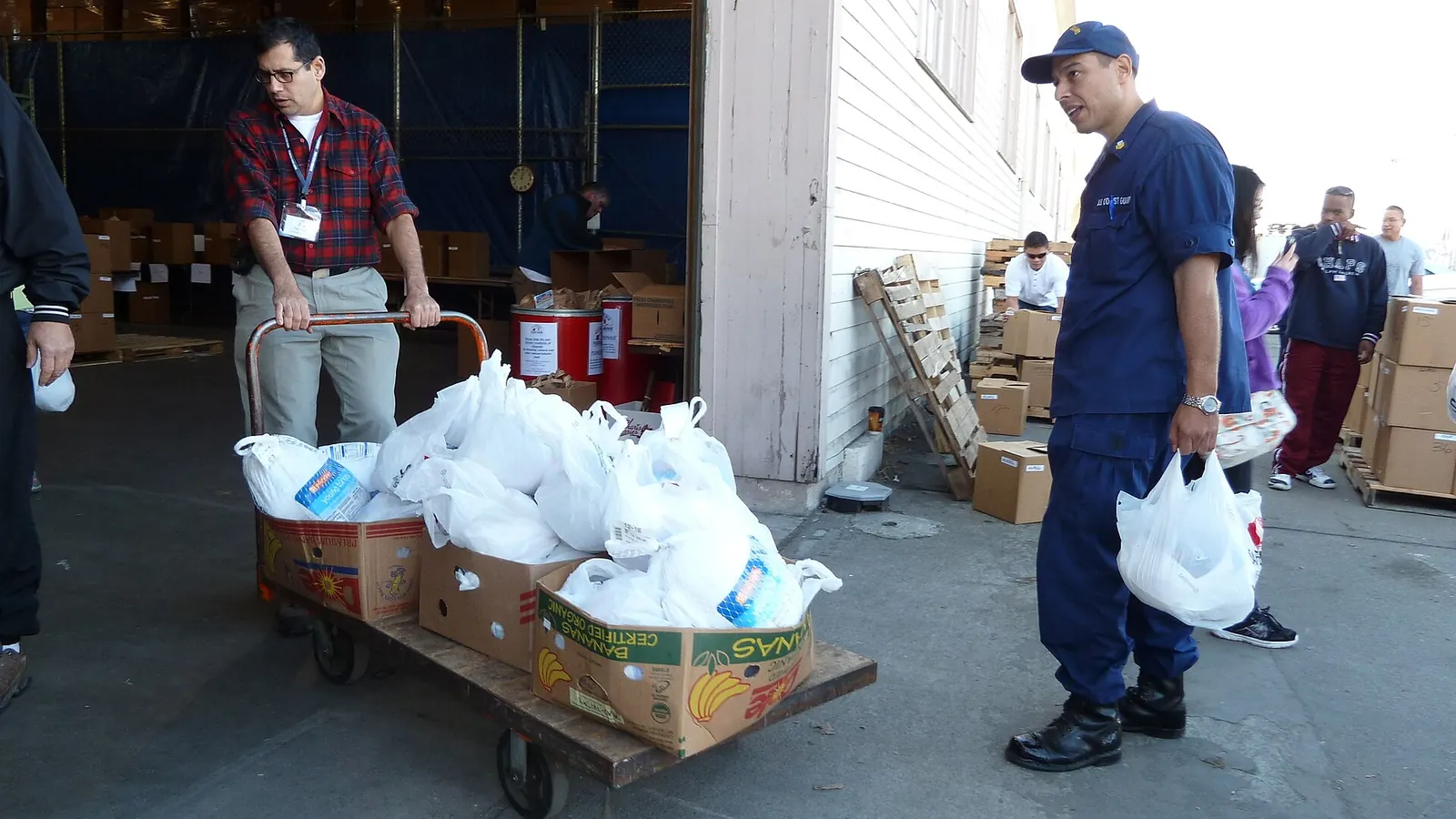 Volunteers handing out grocery bags at a Thanksgiving food drive